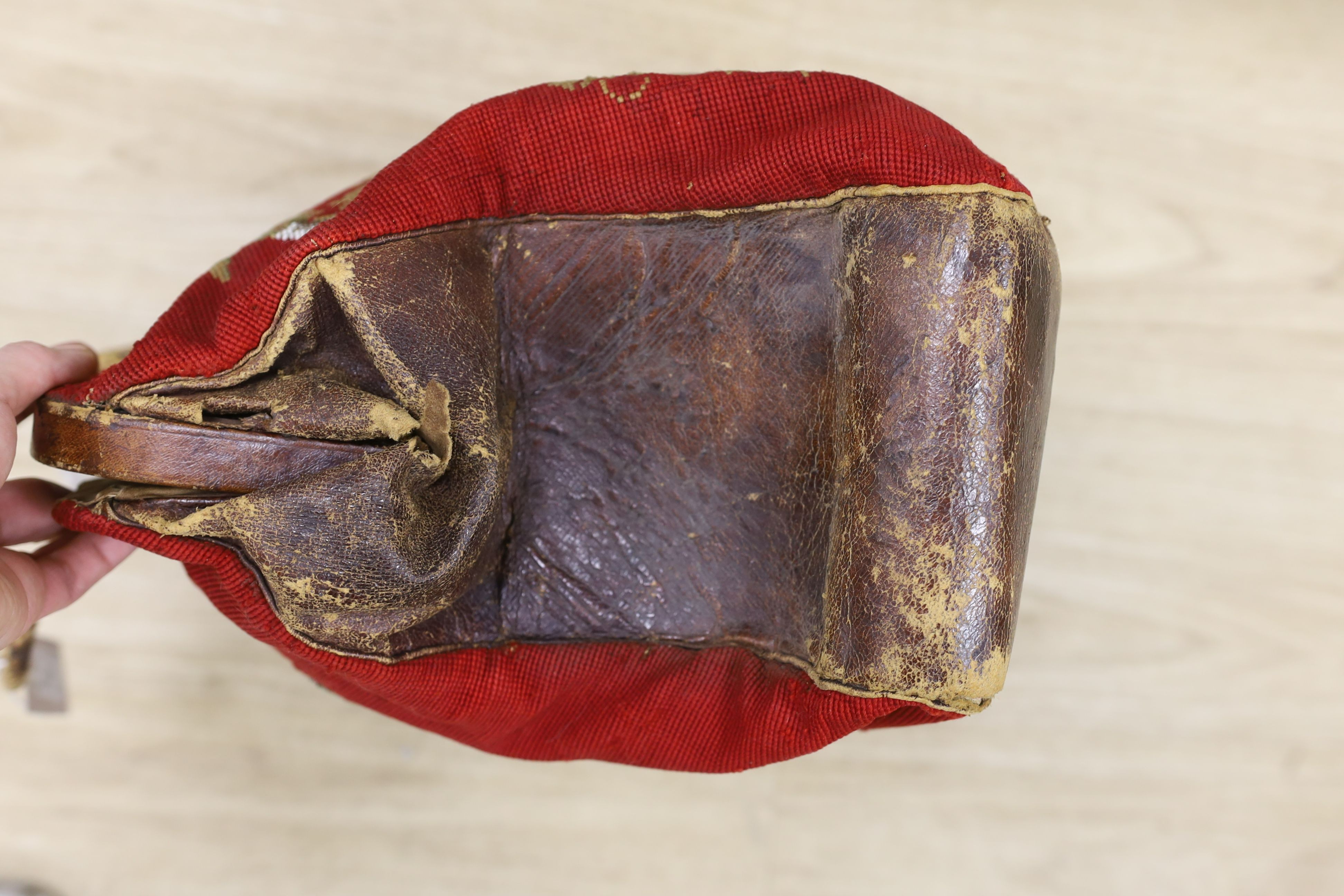 A 19th century Berlin beadwork and leather travel bag, designed one side with a King Charles Spaniel and other with a Terrier and message ‘Bon Voyage’, 46 cms wide x 35 high.